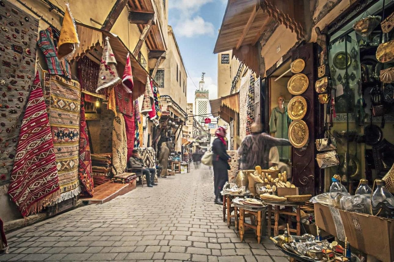 Calle de un zoco con alfombras y artesanía en la medina de Fez