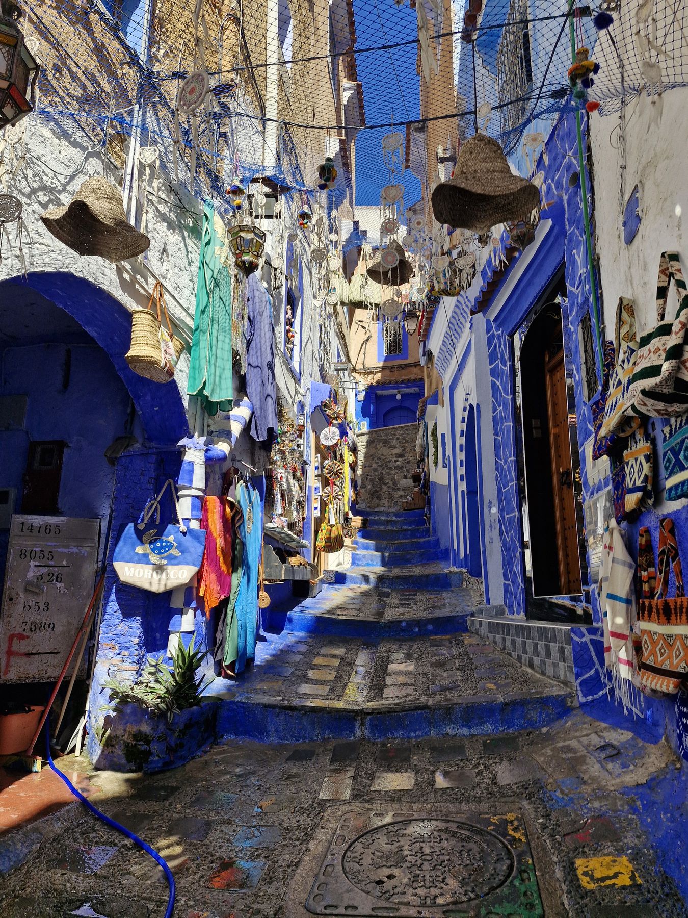 Callejuela azul de Chefchaouen con artesanía colgada en las paredes